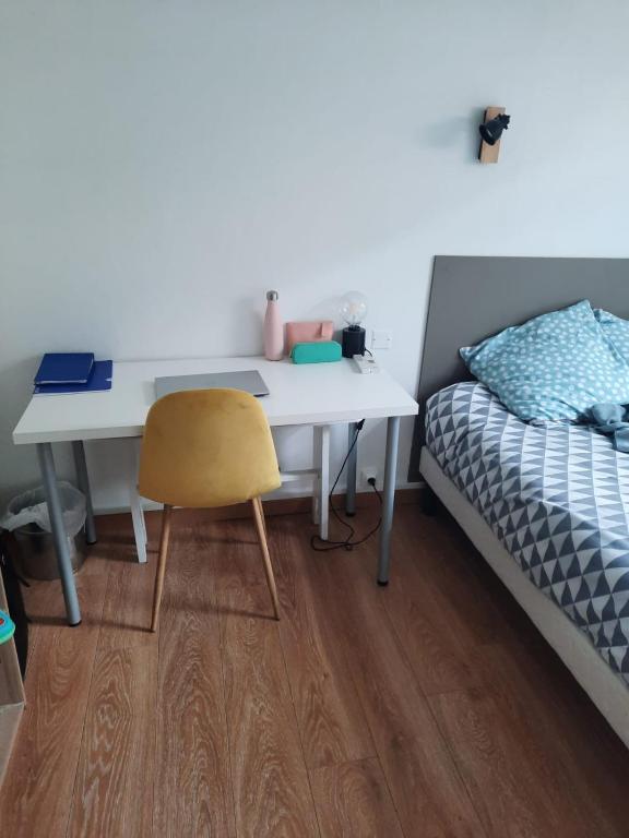 une chambre avec un bureau à côté d'un lit et une table et une chaise dans l'établissement La bulle pétillante, à Reims