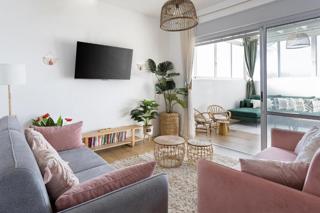 ein Wohnzimmer mit 2 Sofas und einem TV in der Unterkunft שלווה בגלבוע in Gid‘ona