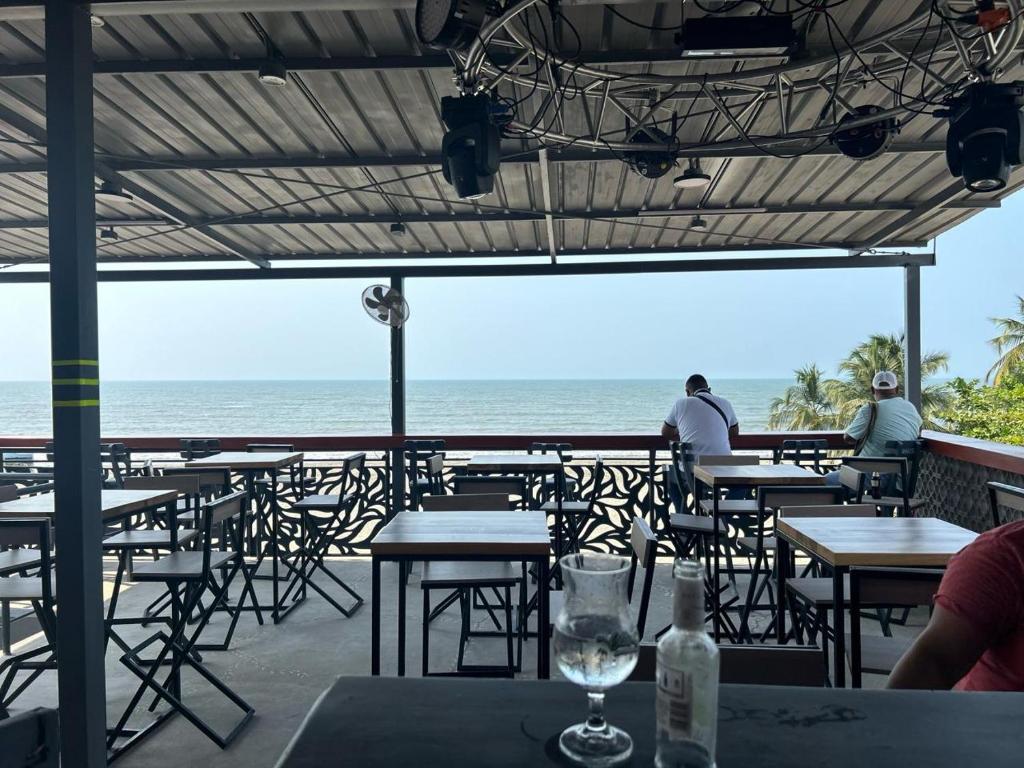 - une vue sur l'océan depuis un restaurant doté de tables et de chaises dans l'établissement Habitaciones villa oti, à Ciénaga