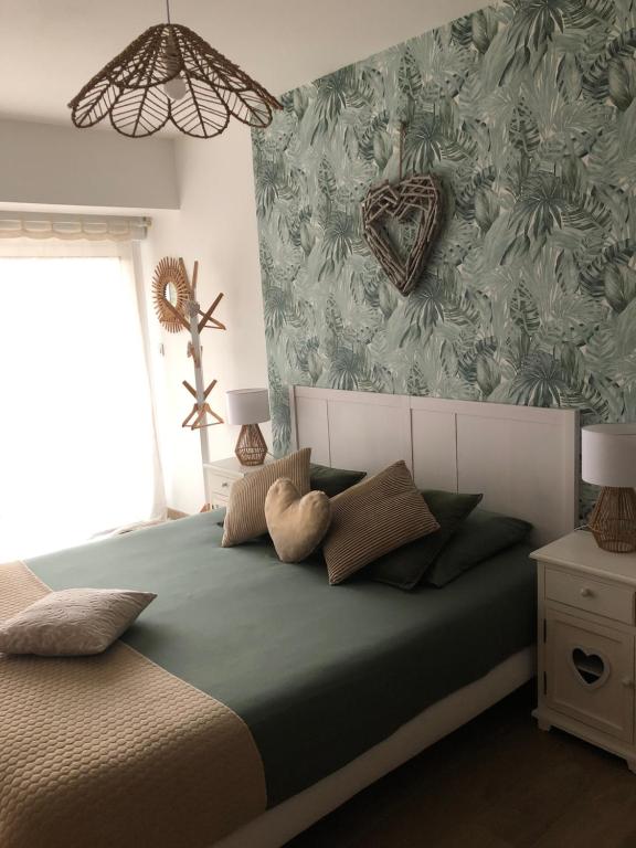 una camera con un letto con una parete verde di La Carola a Bordeaux-Saint-Clair