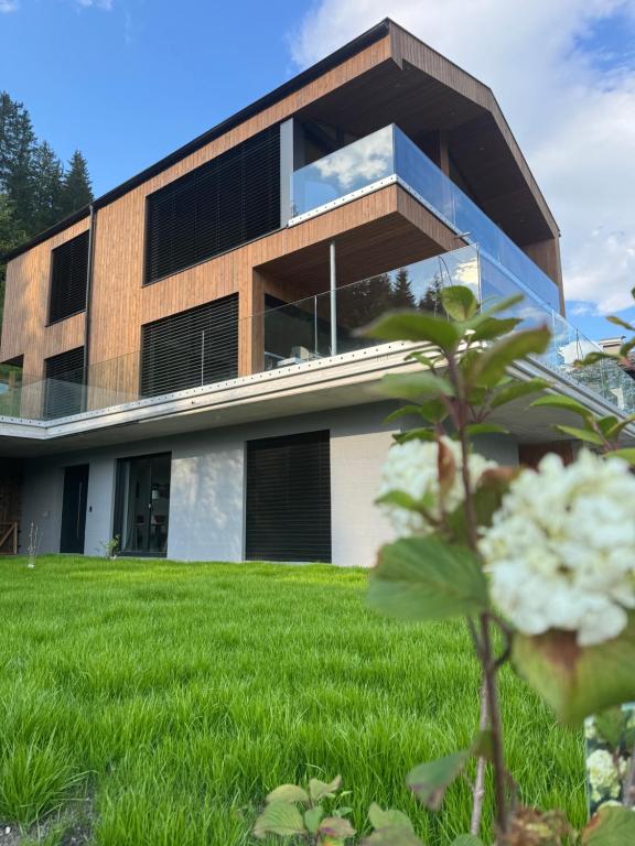 a house with a green lawn in front of it at Loder Lodge in Sankt Jakob in Haus