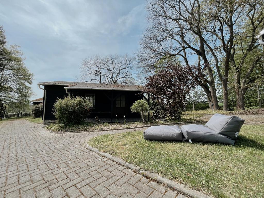 a couch laying on the grass next to a house at Ludwigslust, deine Rückzugsoase in Mehltheuer