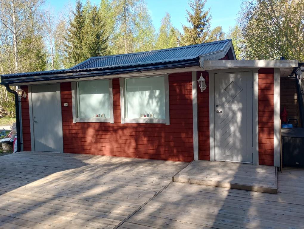 een rood bakstenen huis met twee ramen en een veranda bij Ackes Stuga 32 in Örebro