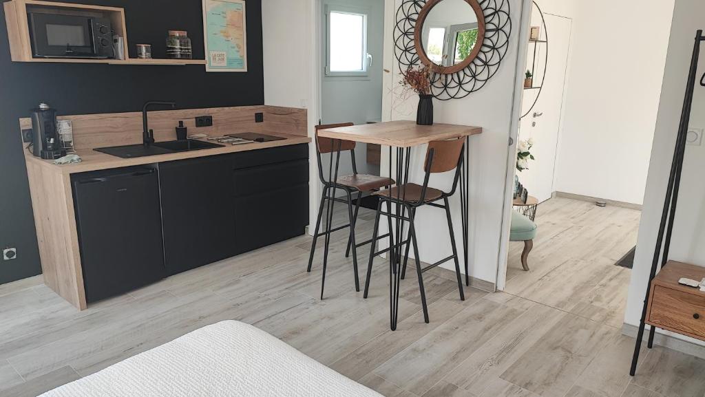 a kitchen with a counter and a sink and a bar stool at Studio mer in La Plaine-sur-Mer