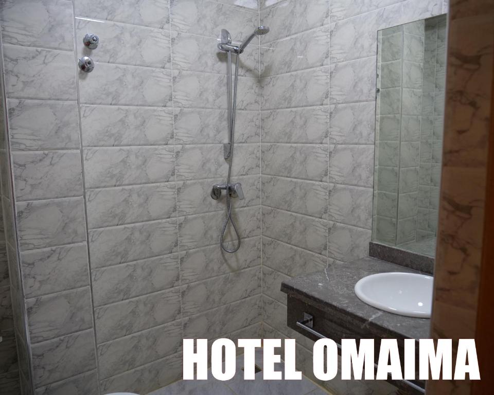 un bagno con doccia, WC e lavandino di Hotel OMAIMA a Laayoune