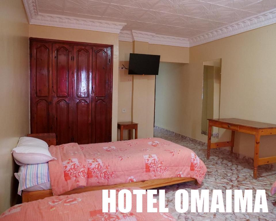 una camera d'albergo con due letti e un tavolo di Hotel OMAIMA a Laayoune