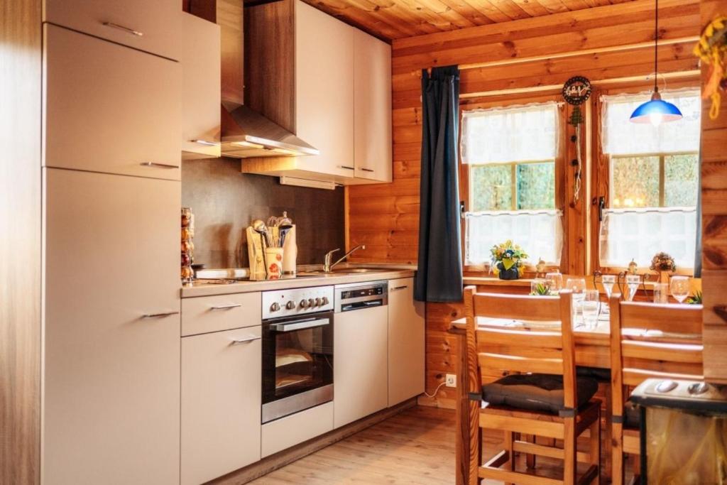 a kitchen with white appliances and a dining table at Blockhaus 2 in Steina
