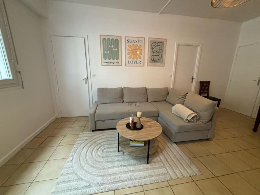 ein Wohnzimmer mit einem Sofa und einem Tisch in der Unterkunft Appartement à Sceaux, à 20 min de Paris centre in Sceaux