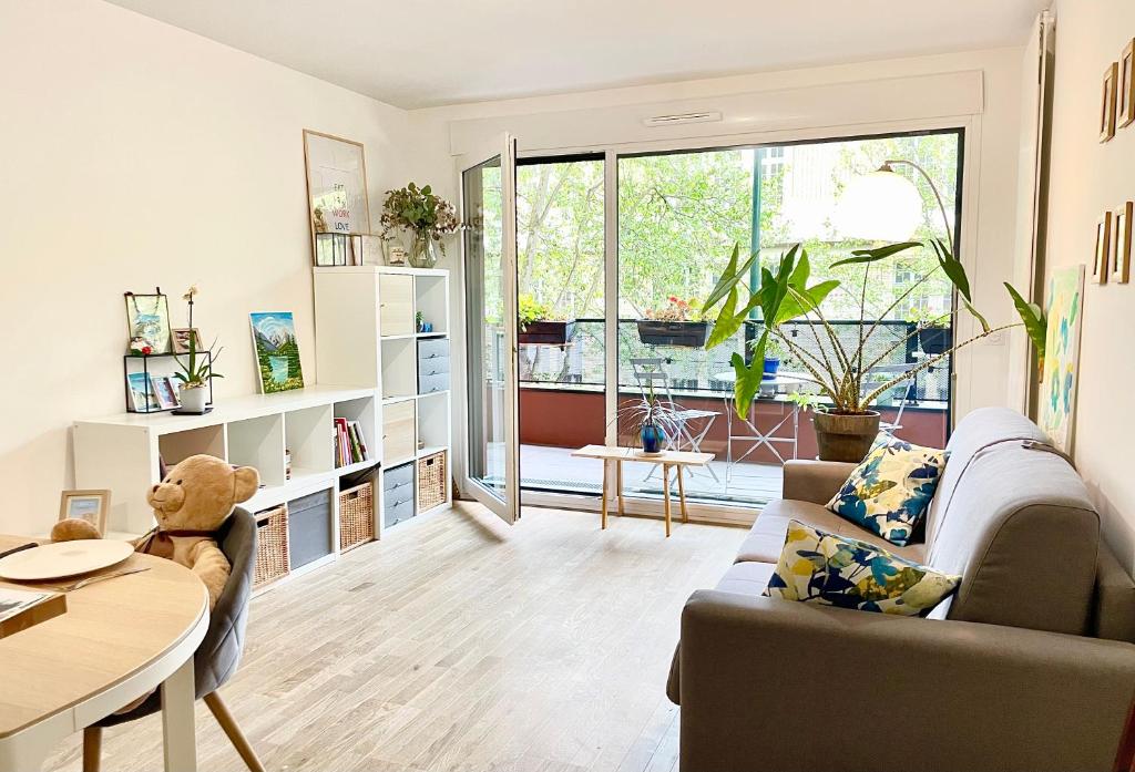 a living room with a couch and a table at Cosy and Spacious appartement near metro line 4 & RER B in Bagneux