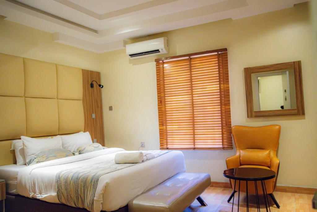 拉各斯的住宿－Box Residence Hotel，卧室配有床、椅子和窗户。