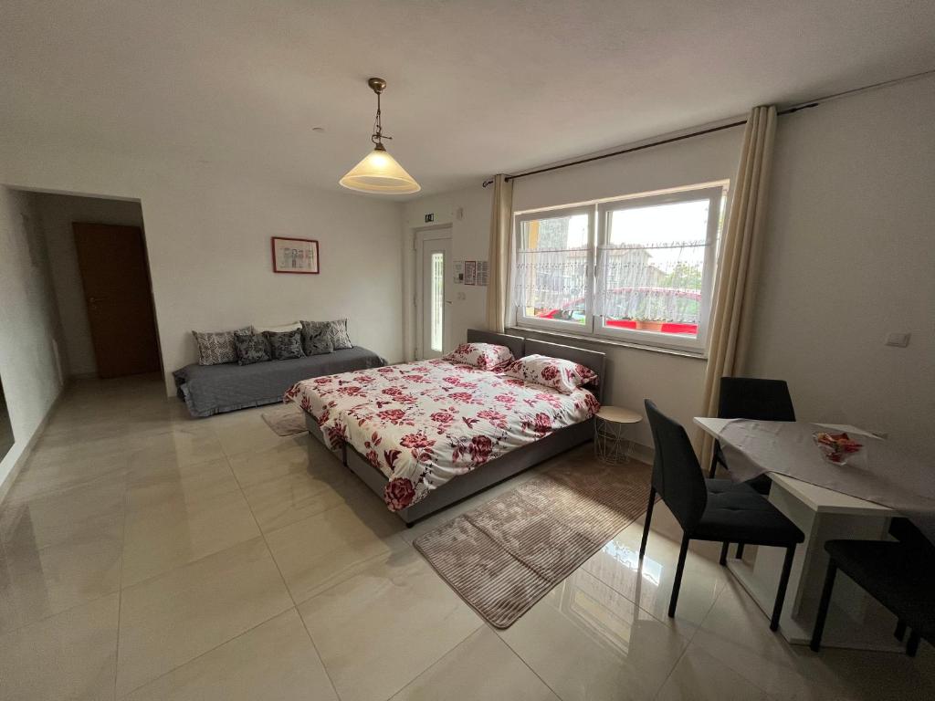 ein Schlafzimmer mit einem Bett, einem Sofa und einem Tisch in der Unterkunft Apartma Azurre in Postojna