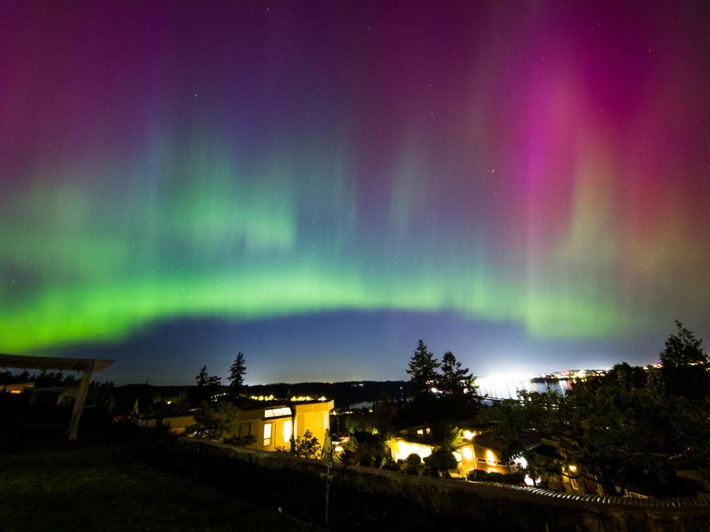 an aurora in the sky over a city at HOV B&B House -Hospitality Ocean View Victoria- in Victoria