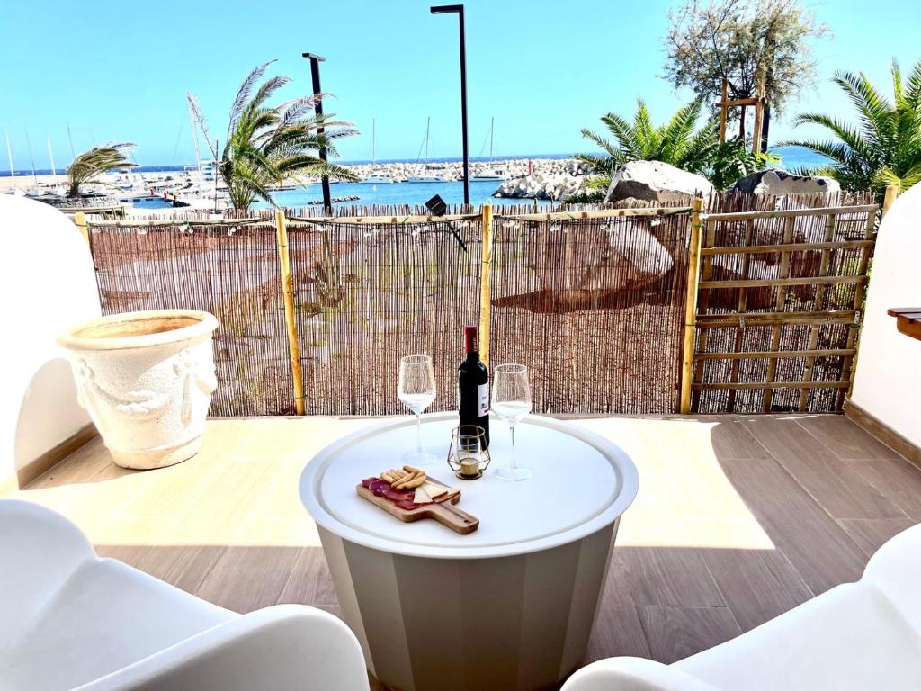 stół z butelką wina i dwoma kieliszkami w obiekcie Seafront Apartment in Amarilla Golf w San Miguel de Abona