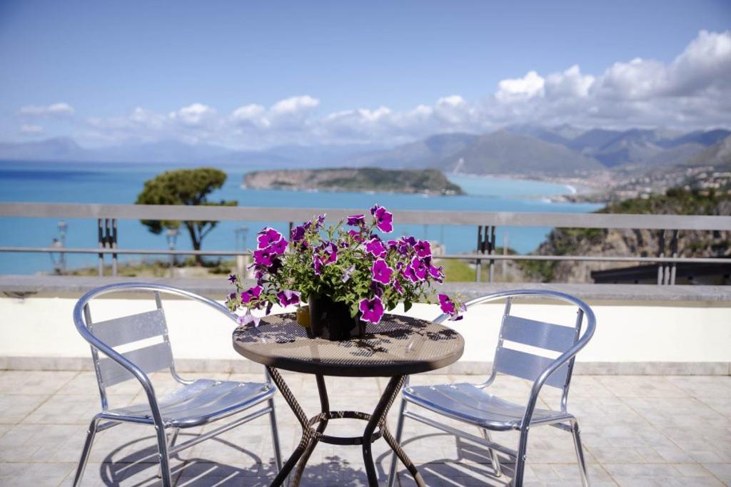 a table with two chairs and a vase of purple flowers at Hotel Villa Principe in San Nicola Arcella