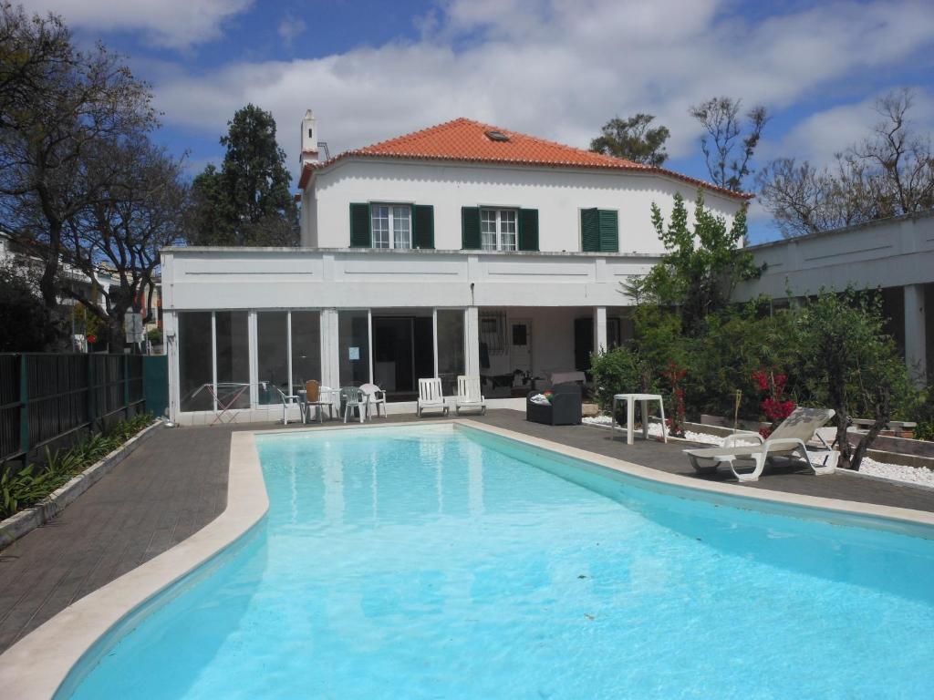 a large swimming pool in front of a house at Lisbon Blue House in Oeiras