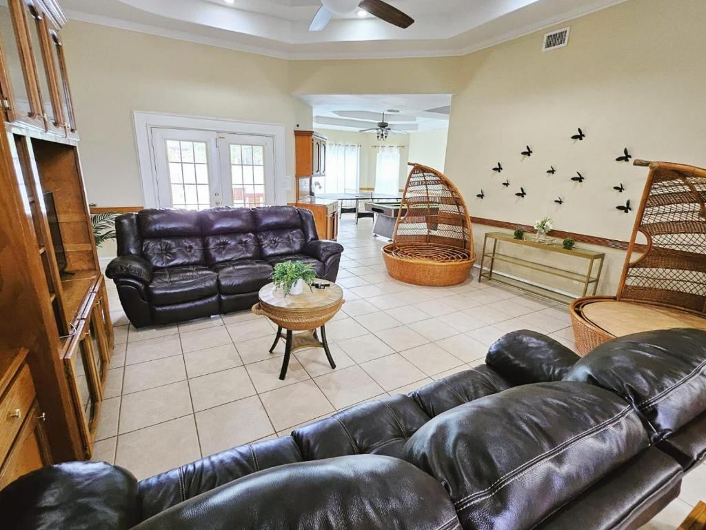 a living room with a leather couch and a table at Beautiful house with pool in Mission