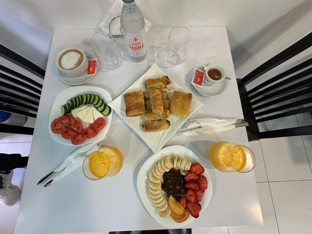 une table avec des assiettes de nourriture et des tasses de café dans l'établissement Hotel Europa Kruje, à Krujë