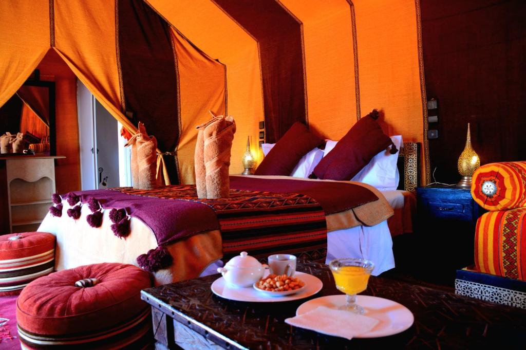 a bedroom with two cats standing on a bed at Merzouga Paradise Luxury Camp in Merzouga