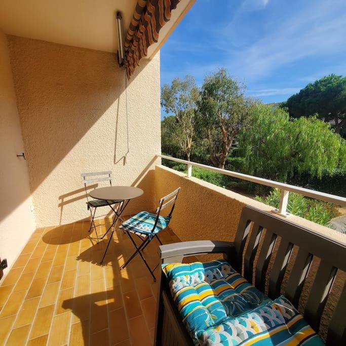 un balcon avec un canapé, une table et des chaises dans l'établissement Délicieux Studio 3 p climatisé La Faviere, à Bormes-les-Mimosas