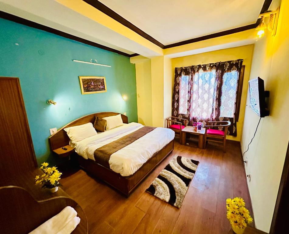 Hotel Tara Regency - A family Hotel في شيملا: غرفة نوم بسرير كبير ونافذة