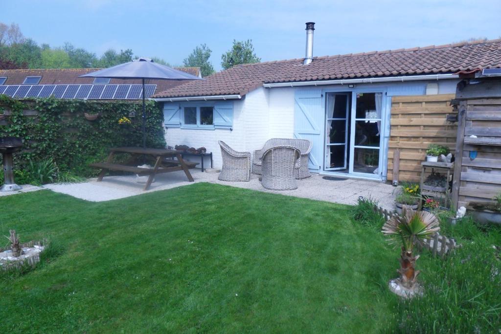 a backyard with a table and a picnic table in a yard at Mi Corazon huisnummer 122 in De Panne