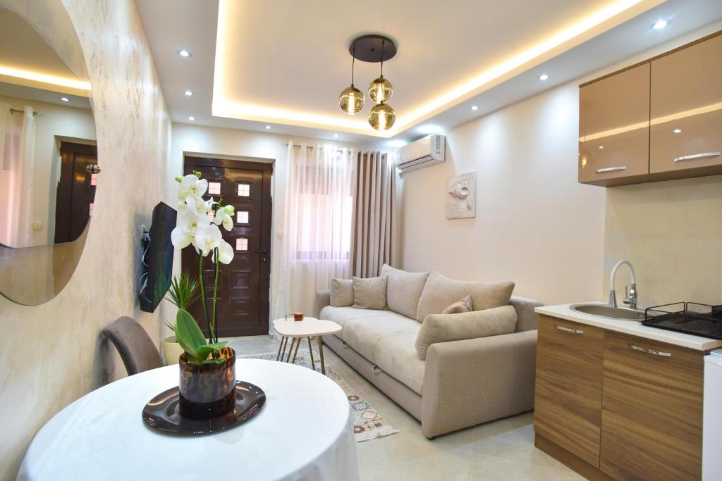 una cucina e un soggiorno con divano e tavolo di Vila Apartments Lidija a Petrovac na Moru