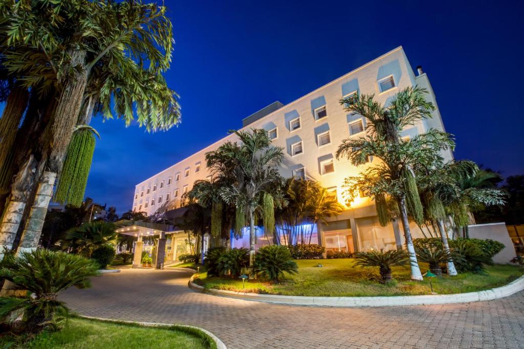 a building with palm trees in front of it at Radha Hometel in Bangalore