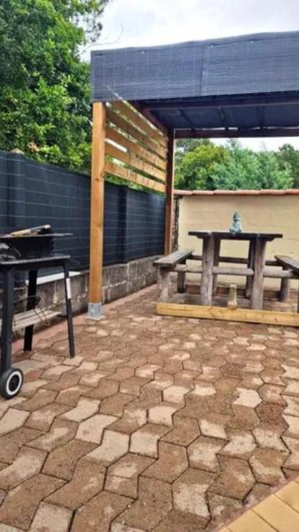 une terrasse avec une table de pique-nique et une table de pique-nique. dans l'établissement Le refuge boisé, à Mimizan