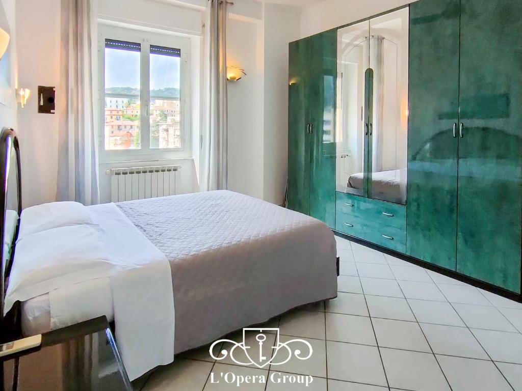1 dormitorio con 1 cama grande y espejo grande en Brezza d'Estate - L'Opera Group en La Spezia