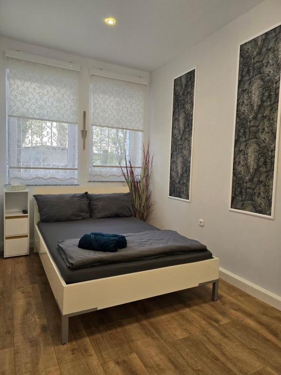 - un lit dans une chambre avec 2 fenêtres dans l'établissement B&R Süd Nürnberg, à Nuremberg