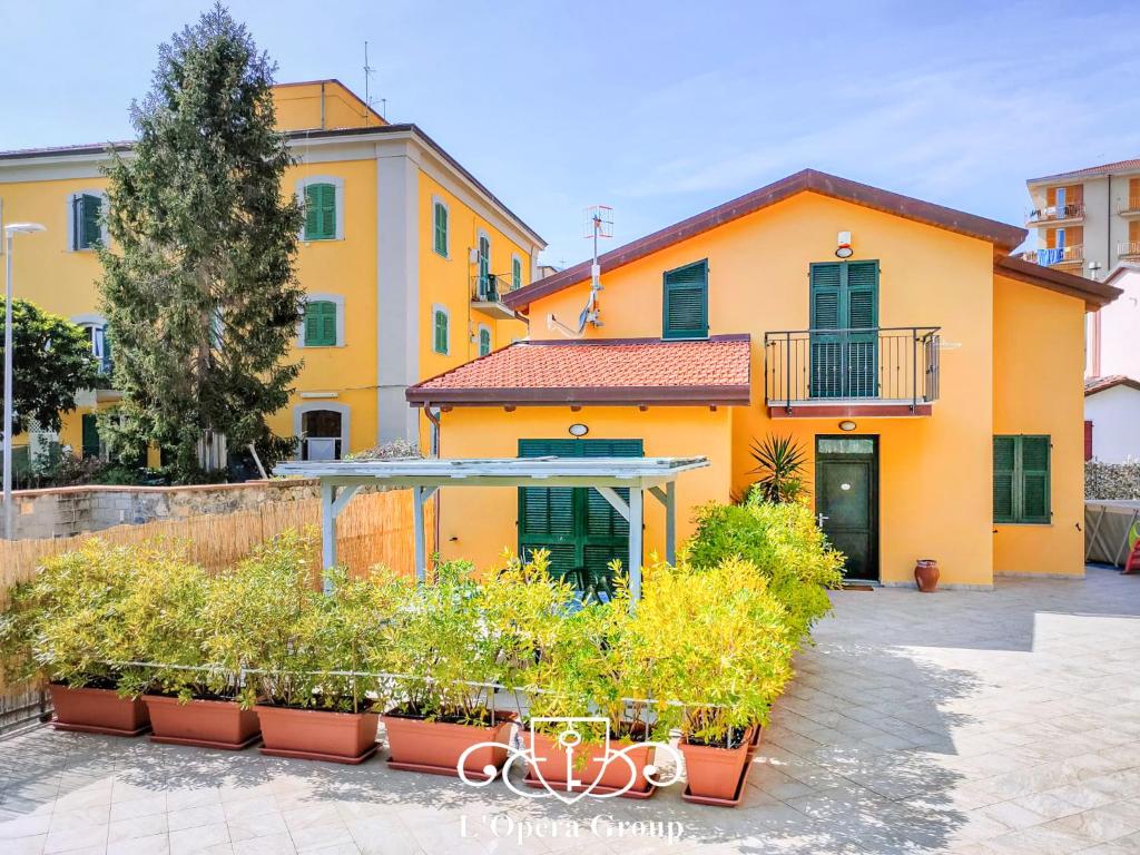 un bâtiment orange avec des plantes devant lui dans l'établissement Villa Livia - L'Opera Group, à La Spezia