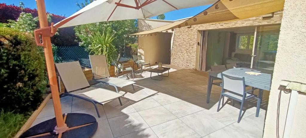 Aurec-sur-LoireにあるStudio cosy avec terrasse et accès piscineのパティオ(テーブル、椅子、パラソル付)