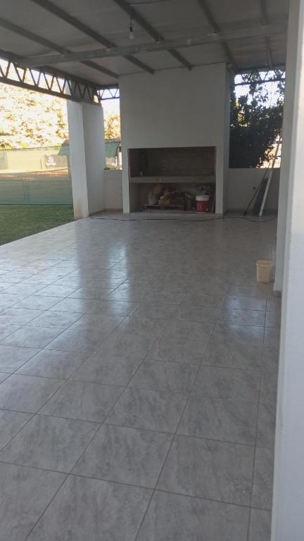an empty patio with a large tile floor at Quinta El Pinar Tenis in San Nicolás de los Arroyos