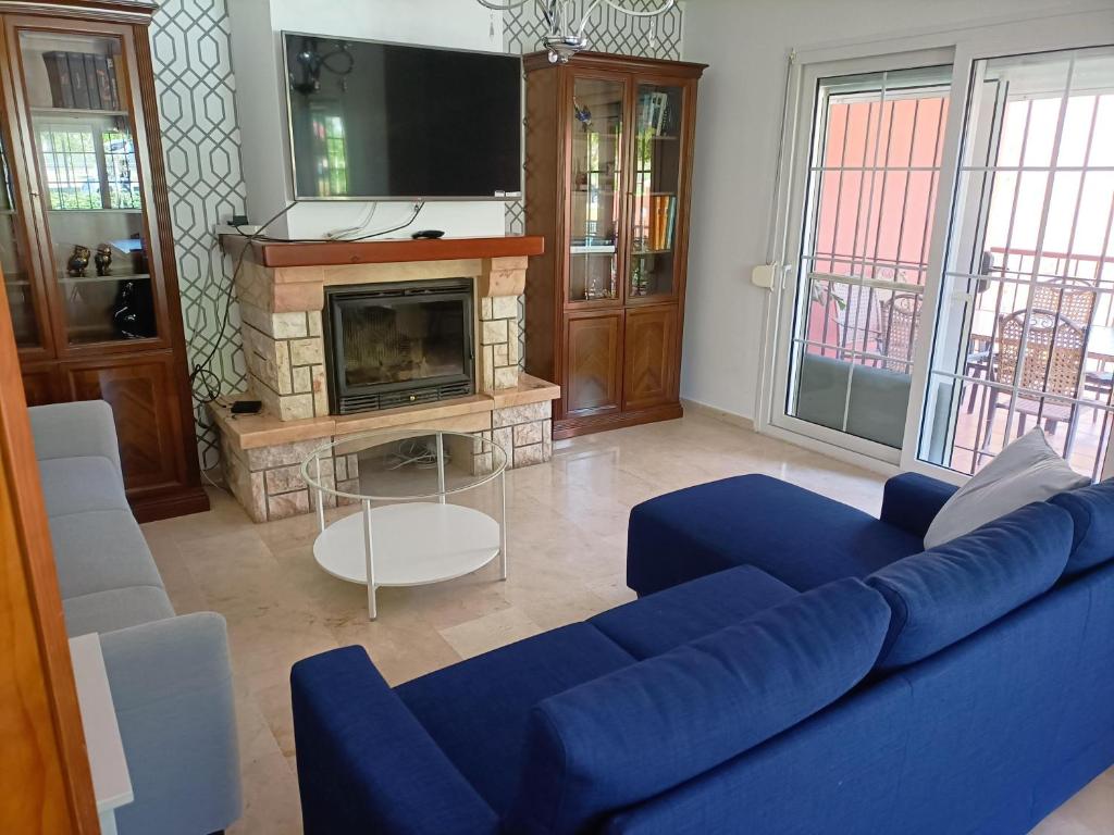 a living room with a blue couch and a fireplace at Villa Matisse Luxury Beach in Torremolinos