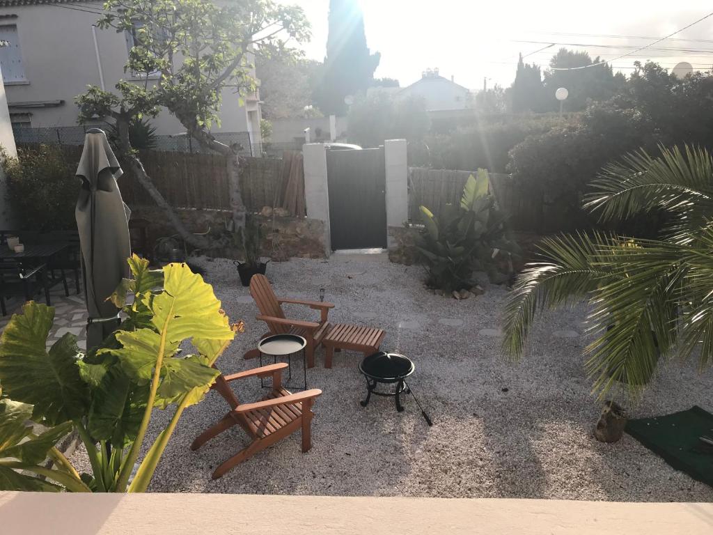 un patio avec deux bancs et un barbecue et une clôture dans l'établissement Le cabanon détente, à Bandol