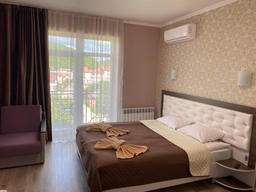 ein Schlafzimmer mit einem großen Bett und einem Fenster in der Unterkunft Апартаменти в "Арена Віладж" in Poljana