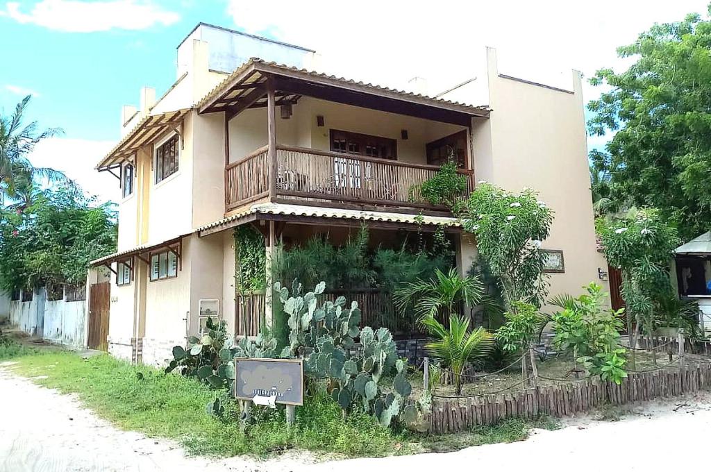 uma casa com varanda e plantas em frente em #residencialvillajeri - CASA térrea com VARANDA, máq de lavar, 300m da PRAIA em Jericoacoara