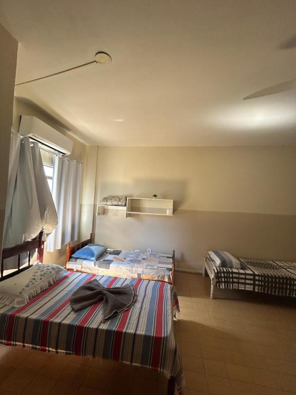 1 dormitorio con 2 camas y ventana en Hotel Centro en Corumbá