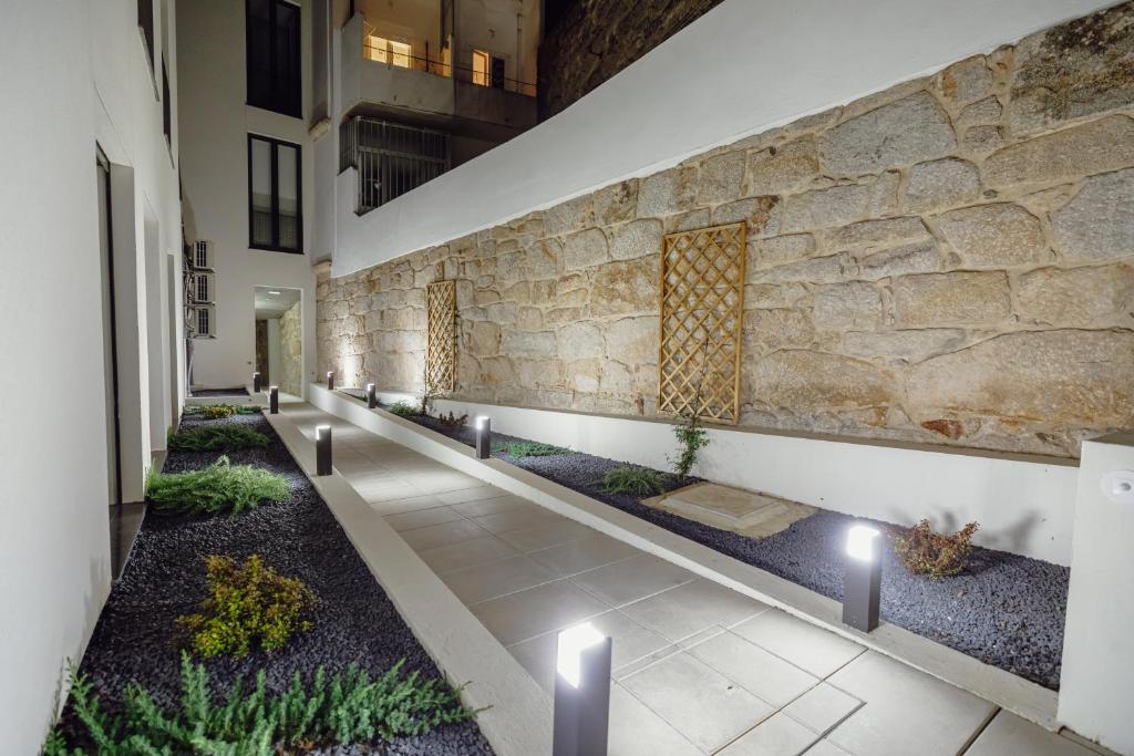 un pasillo con una pared de piedra y plantas en Courtyard Oporto Design Apartments by Vacationy, en Oporto