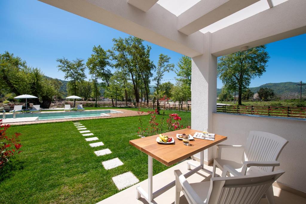 un patio con tavolo, sedie e cortile di Theros Serenity Suites a Olympiada