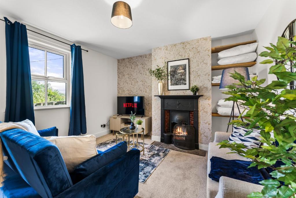 a living room with a blue couch and a fireplace at Peaceful Retreat In The Bath Cotswolds Sleeps 15 in Bath