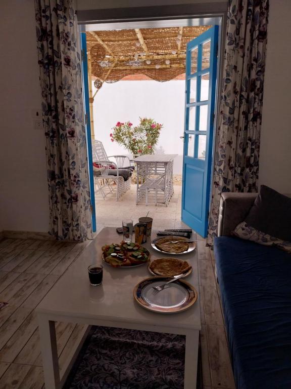 ein Zimmer mit einem Tisch und Teller mit Lebensmitteln darauf in der Unterkunft desert pearl beautiful cosy new home in Luxor