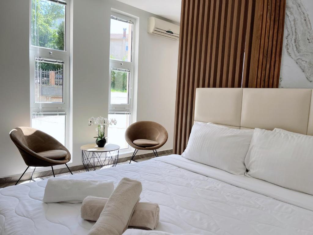 1 Schlafzimmer mit einem weißen Bett und 2 Stühlen in der Unterkunft Guest House Koliqi in Ulcinj