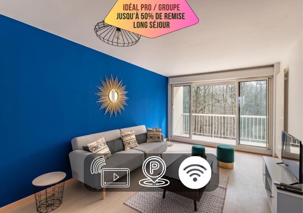 een woonkamer met een bank en een blauwe muur bij Le Mans Est - Idéal Pro & Groupe - 8 maxi - Wifi in Allonnes