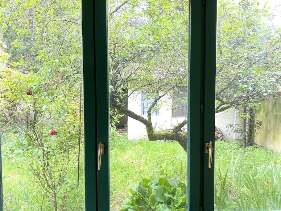 ein Fenster mit Blick auf den Garten im Freien in der Unterkunft Appartement/maison avec jardin in Noisy-le-Sec