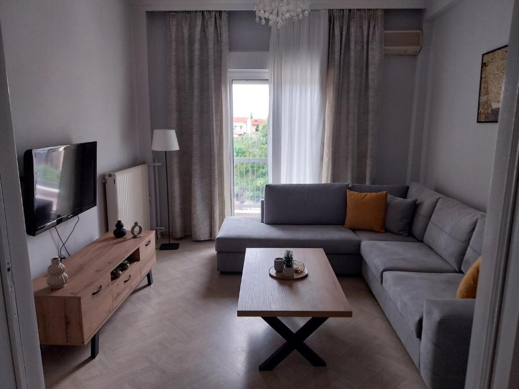 a living room with a couch and a tv at Vasiliki's place in Karditsa