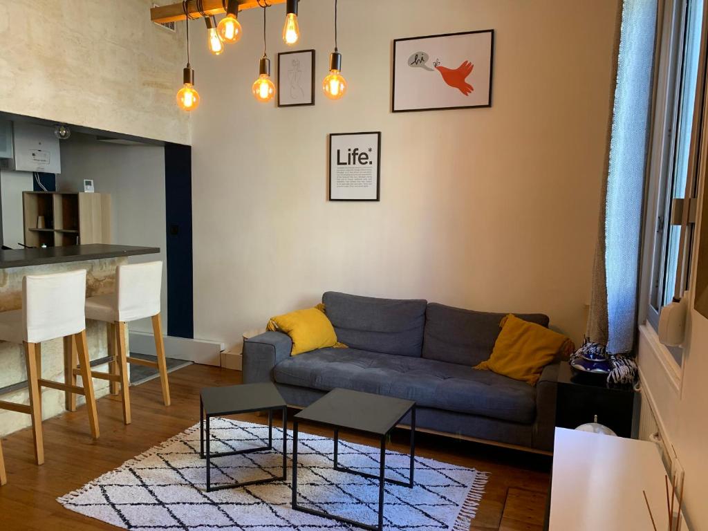 un salon avec un canapé bleu et une cuisine dans l'établissement Maison échoppe - Bordeaux, à Bordeaux