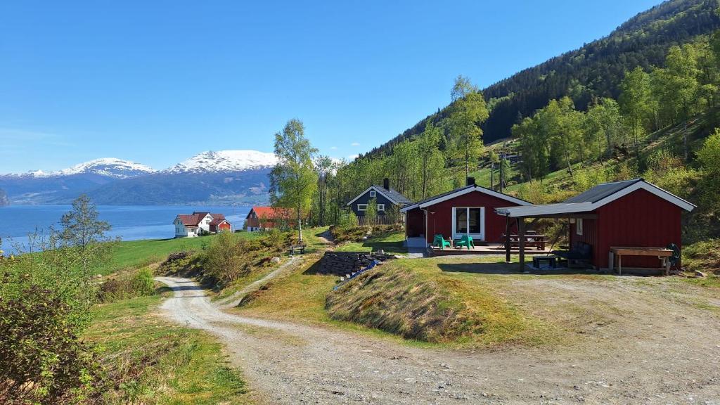 Nordfjordcabins Utvik في Utvik: منزل على جانب تل بجوار الطريق