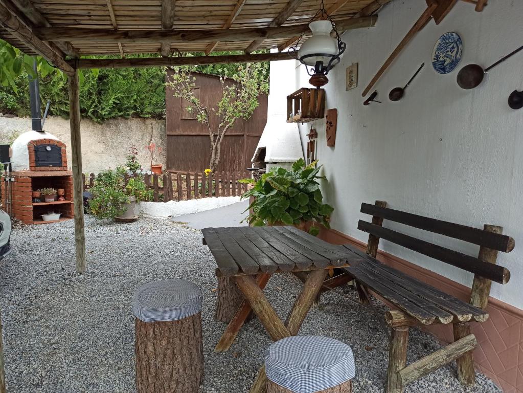 a wooden bench sitting under a pergola at Casita de Campo El Bujeo in Quéntar