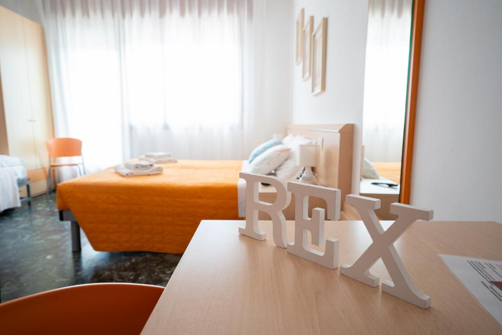 a room with a bed and a table with a sign that says rail at Residence Rex in Chioggia